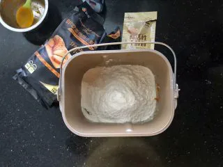 南瓜豆沙排包,2、把主面团里除了黄油之外的所有材料放入面包桶里,先液体后粉类,干酵母最后再放。