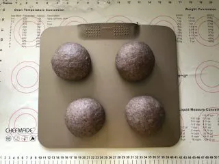 黑加仑黑米软欧包,14、收口朝下有间距的码入烤盘中，盖上保鲜膜进行二次发酵。