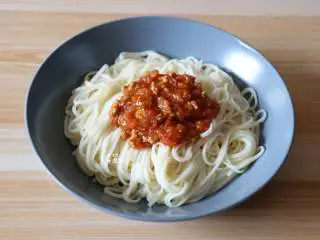 番茄肉酱拌面,再捞出装盘，滴几滴玉米油、撒适量盐、浇上熬煮好的肉酱即可；
