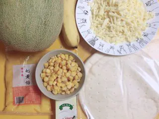 蜜瓜蔬果披萨,准备好食材。哈密瓜、披萨饼底、玉米粒、香蕉、奶黄馅、淡奶油、芝士碎。