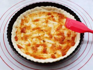 海虾杂蔬披萨,烤好定型后的披萨面皮从烤箱取出以后,先加入披萨酱后,用铲子把披萨酱抹均匀。