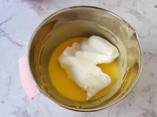日式棉花蛋糕,将三分之一的蛋白倒入蛋黄中,翻拌均匀