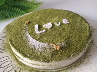 抹茶千层蛋糕,取出蛋糕,表面撒一层抹茶粉,中间吊坠两块金箔装饰