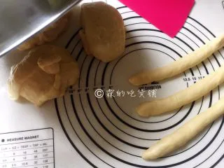一发的淡奶油辫子面包,称一下面团的实际重量，平均分成四份（也可以分成你想要做的份数），去一个团再平均分成三份，分别揉圆后搓成长条（另外暂时没用到的三个面团，用盆或者保鲜膜盖起来以防表皮吹干）。