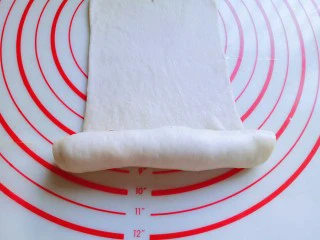 #甜味#毛毛虫豆沙面包,再长舌状面皮的另一端从下往上卷起来，卷到一半时停下来，如图。