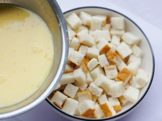 酥脆软滑的蛋奶吐司布丁,将蛋奶液倒入面包丁中,先倒入少许,