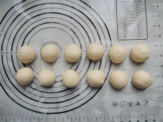砂糖麻花面包,发酵好的面团倒出来,轻按排气,分割成12个等份的小面团,分别揉圆,盖上保鲜膜松弛20分钟。