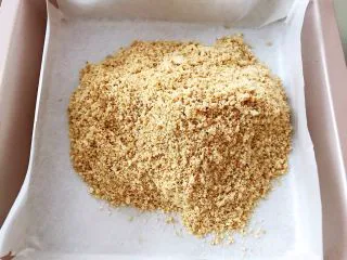 芝士控最爱的蔓越莓芝士条,烤盘里铺上油纸 饼干用擀面杖擀成碎末