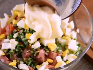 美味西餐土豆沙拉的做法,将炒好的料倒入土豆泥中,依次加入黄瓜粒、鸡蛋粒、色拉酱,搅拌均匀
