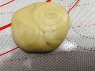 酥到掉渣的豆沙蛋黄酥,你要来一个吗?,拿一个面团,按压中间,向中间压扁,擀开。