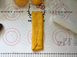 南瓜豆沙排包,11、两边向中间折叠,稍微擀长点。