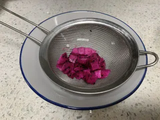 火龙果渐变蛋糕(宝宝辅食),切一点火龙果丁,形状较规整的留起来待会做装饰,边角部分压碎出汁,注意我们只取果汁