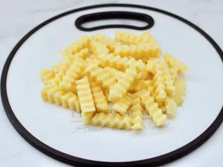 炸锅版狼牙薯条,首先把土豆去皮后,用狼牙刀切片条状。