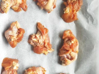 比外卖还好吃的秘制烤翅根,在烤盘上铺一张干净的油纸，把腌制好的翅根均匀的放在烤盘上。