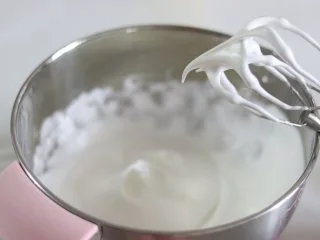 瑞士蛋糕卷之雪融蛋糕,做圣诞应景美食,蛋白打散,加入2-3滴柠檬汁后,分约2次加入细砂糖打发蛋白。 直到状态细腻有光泽,拉起打蛋头,出现弯钩的状态即可。