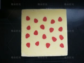 草莓彩绘蛋糕卷,然后反过来放晾架上，撕掉油布。停留一分钟，让蛋糕稍微冷却一下。草莓图案和蛋糕是平面一体的。