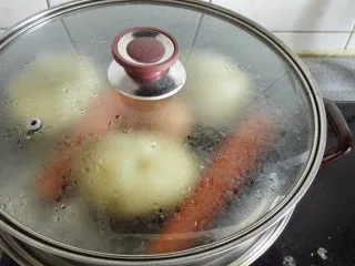正宗西式土豆沙拉, 差不多的时候放入鸡蛋和胡萝卜，因为鸡蛋和胡萝卜熟的快，可以晚点放口感好，否则鸡蛋会硬，胡萝卜太软。蒸到可以用筷子轻松扎透土豆即可，同样方法