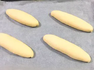 奶油夹心面包,放入烤盘，送入烤箱两次发酵，方法同上也是60分钟，发酵完成后表面刷鸡蛋液。