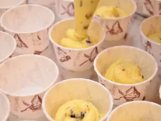 杏仁玛芬蛋糕 简单烘焙,将面糊装入裱花袋，挤入中号纸杯中，约7分满。震动烤盘，使面糊布满纸杯。