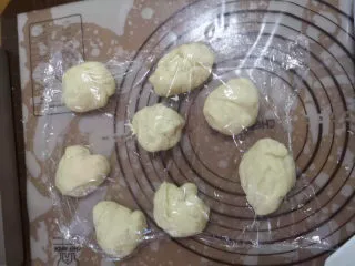 儿时的味道～脆皮蜂蜜小面包,分成大小均匀的八个小面团，盖上保鲜膜松弛15分钟。