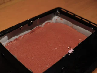 红丝绒蛋糕 无需酪乳 奶酪霜抹面,模具的尺寸是23*15cm，高度3cm，也可以用6寸圆模，做出来高度大概6cm，垫上烤纸。 倒入面糊。 用刮板把表面刮平整。175度烤30分钟。 6寸圆模烤40分钟。