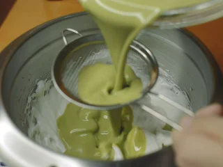 抹茶魔法蛋糕,抹茶面糊过筛倒入蛋白霜。 先倒一半。翻拌几下,以不拌匀为目标。