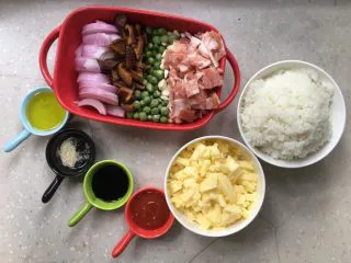 芝士培根焗饭,准备好所有原材，洋葱切丝，香菇泡软切片，培根切块，芝士碎、油、蕃茄酱、胡椒粉、生抽、青豌豆、玉米粒和米饭等备好。