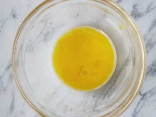 欧式风情下午茶|加了苹果的蛋挞,另取一个碗,把准备好的鸡蛋蛋黄磕入碗中,用筷子搅散备用。