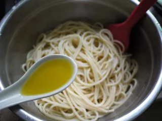 培根芝士意大利面,把煮好的面捞出,无需冲冷水,只需加一勺橄榄油,然后把面拌均匀,橄榄油的作用是防止面粘在一起。