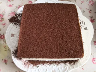 提拉米苏(蛋糕版),最后把淡奶油糊全部倒入,轻震几下,使表面平整,入冰箱冷藏至凝固,这里放了一个晚上,取出成形的提拉米苏,用电吹风在周围吹1-2分钟,就可以脱模了,如果天气热,也可以取了来放一会,用手在周围捂一下,也可以顺利脱模,表面撒上可可粉,就可以食用啦。