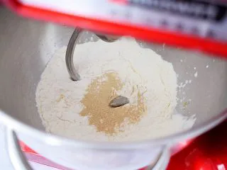 日式炼乳手撕面包,把材料除了黄油外全放入厨师机中,启动1档慢速揉成团,再转3档快速揉成光滑的面团