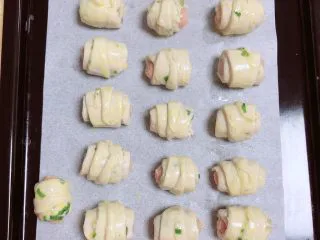 葱油飞饼香肠卷,肉卷表面刷一层薄薄的蛋黄液。提前预热烤箱，180度预热5分钟。