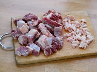 #食二星座#法式红酒炖牛肉 Boeuf Bourguignon,2.牛肉要选择有肥有瘦，最好带有少量骨头，或额外加几块腿骨。 先将牛肉泡水半小时，为了泡出血水；然后切成大方块，清洗干净，控干水分。（这一过程很重要，不然接下来的煎制就会变成煮）。 如脂肪过多，将其切下来，切成小粒炼油，做为煎牛肉的用油。