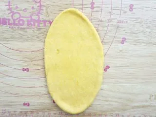 南瓜泥黄金软排包,擀开成椭圆形 