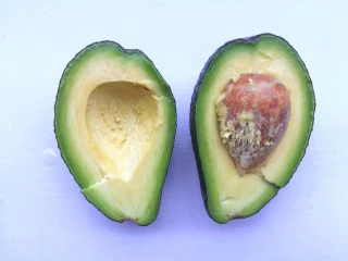 牛油果鸡蛋火腿三明治,牛油果切开拧出果肉。