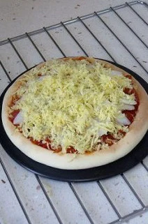 玄妙感觉的孜然羊肉披萨,将炒好的披萨酱铺入饼底,上边码放一层山药片,再铺一层马苏里拉奶酪。