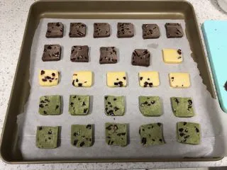 蔓越莓曲奇(原味&可可&抹茶),把曲奇片放入铺了油纸的烤盘中,注意每一片曲奇之间要有间隔,防止烤制的时候面团膨胀粘在一起