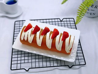 红丝绒草莓奶油蛋糕卷~下午茶必备甜品,留下的奶油装入裱花袋,挤在蛋糕卷上,又装饰了草莓,这样就完成啦。