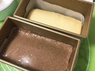 黑砖蜜豆吐司,面团发酵完成后取出,倒入蛋糕糊,倒入跟面团平后震几下,使蛋糕糊渗入细缝中。