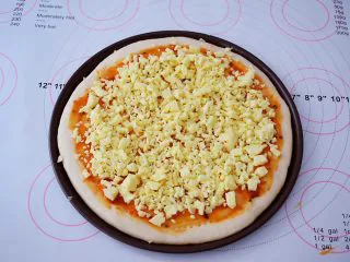 杂蔬火腿肠披萨,先撒上一层芝士碎