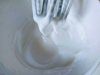 8寸戚风蛋糕,电动打蛋器高速打发，打至湿性发泡时加入最后的三分之一糖，，继续打发至蛋白出现细腻的纹路，将电动打蛋器调低速打发一会儿，感觉有些阻力时，就可以停止打发，以免消泡，提起打蛋器有微微的弯勾就可以，如图