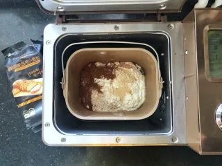 可可冰心面包,1、首先制作可可餐包。把主面团里除了黄油之外的所有材料放入面包桶里，先液体后粉类，干酵母最后再放，面包桶装入面包机中，启动和面功能。