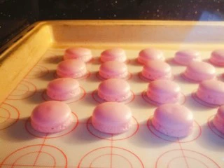 马卡龙~卡仕达酱内陷,晾皮快结束的时候,烤箱150度预热。大概十分钟,把马卡龙放入预热好的烤箱150度烤16分钟。烤好的马卡龙取出等待凉透。