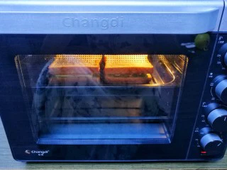 牛油果鸡蛋火腿三明治,放入烤盘,推入预热好的烤箱,180度烤5分钟。放温然后用保鲜膜裹好三明治,从中间切半即可。