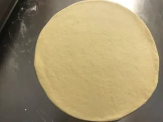 秘制芝心卷边披萨,擀成圆薄片，边缘稍厚些，静置5分钟。