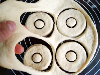 巧克力甜甜圈,多余的面揭起来,揉圆后重复步骤8。刻出来的饼坯加盖保鲜膜,二次醒发30分钟。