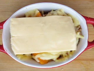 奶香南瓜鸡肉焗饭,再盖上一片芝士，继续放入烤箱至融化。