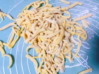 草莓麦片沙琪玛,然后用刀切成长条片状，再改切成条状，并抖开防止粘连