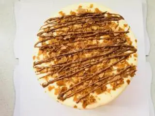 爆浆海盐红丝绒奶盖蛋糕,表面撒上黄油脆片，挤上软化的巧克力。完成。