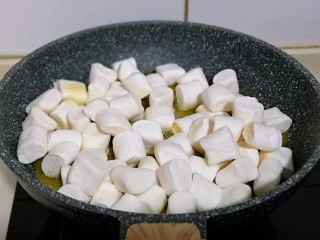 预热圣诞节 蔓越莓雪花酥,这时加入棉花糖，同样小火将棉花糖炒化。(一边炒一边搅拌)